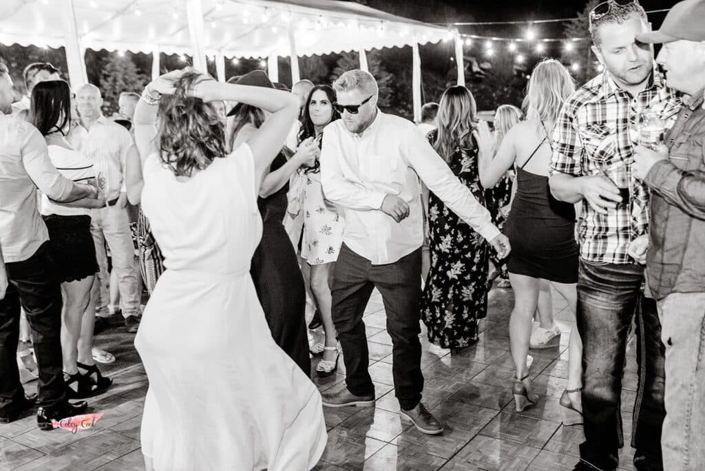 Guy with shades dancing on the dance floor with people around