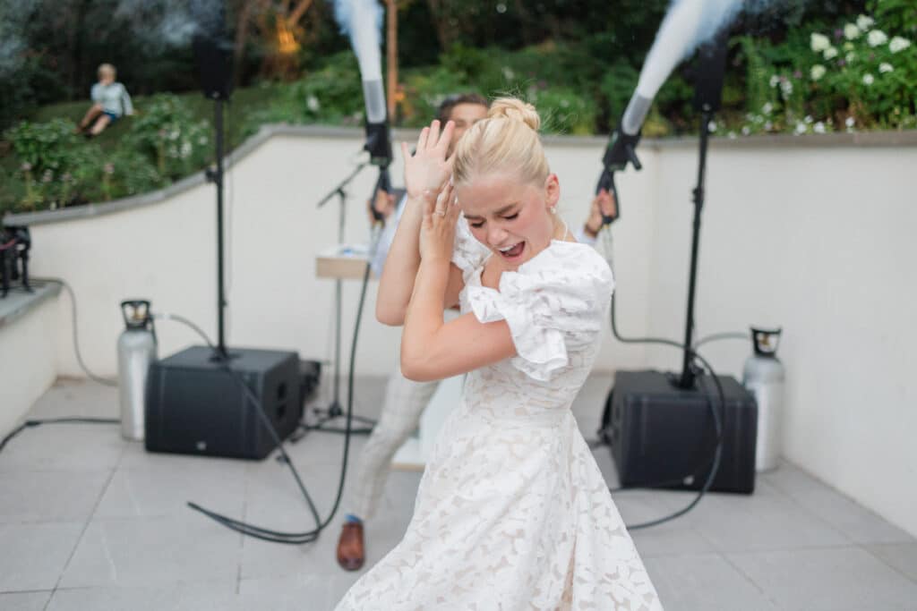 Wedding Reception at Twenty and Creek Braxton shooting co2 guns behind Sara who is dancing